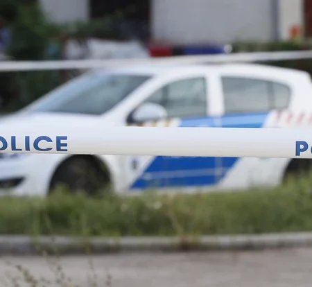 egy rendőrautó parkol a gyilkosság helyszíne mellett